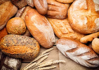 Keuken foto achterwand Brood hoop vers gebakken brood op houten achtergrond