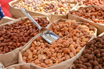 Assorted nuts in paper boxes for sale in the market. Selective focus. Copy space.