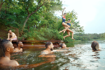 Enjoying river party with friends. Group of beautiful happy young people at the river together