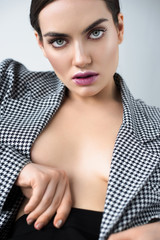 attractive half naked woman posing in retro jacket, isolated on grey