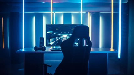 Fotobehang Gaming Professional Gamers Room With Ultra Powerful Personal Computer. Paused First-Person Shooter Game on Screen. Room Lit by Neon Lights in Retro Arcade Style. Cyber Sport Championship.  © Gorodenkoff