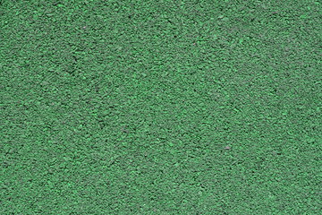 Background image of a colored rubber coating green. Worn sports field cover