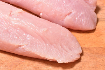 Beautiful and fresh turkey fillet. Fillet of turkey on a wooden cutting board