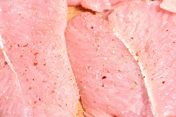 Beautiful and fresh turkey fillet. The fillet of turkey is sprinkled with spices on a cutting board