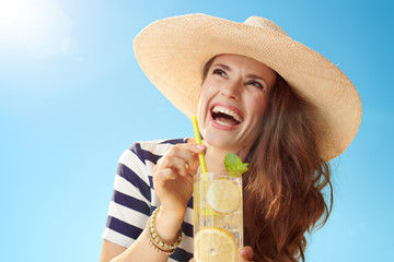 happy woman with refreshing cocktail looking at copy space