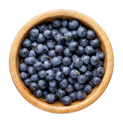 Blueberry berries in wooden bowl isolated on white. Top view.
