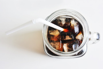 Cola with ice in glass on white background