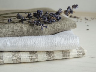 Natural pure linen towels, napkins on tablecloth. Small business. Pile of striped white grey linen cotton fabrics on fabric background. Food photo props. 