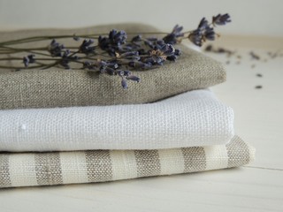Natural pure linen towels, napkins on tablecloth. Small business. Pile of striped white grey linen...