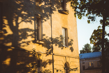 Shadows from trees on the facade of the house. Architecture in the Old Town area in Obninsk, Russia
