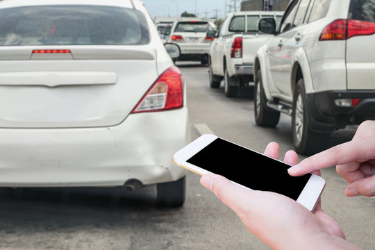 woman hand using mobile smart phone after car crash accident damage at bumper for insurance