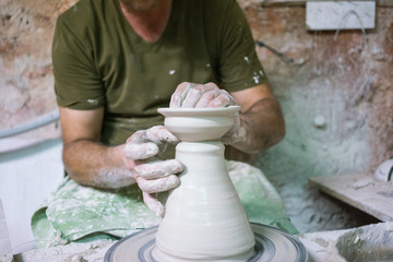 Ceramic dishes in working process. Creating ceramic pieces. Tradicional ceramic factory in spain. man working with traditional potter's wheel