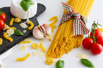 Bunch of uncooked long italian spaghetti tied with a cord in the colours of the national flag on...