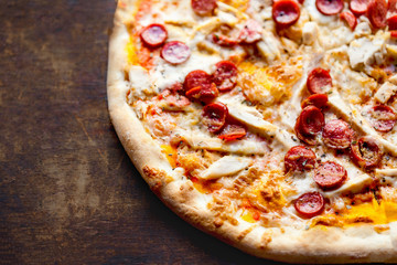 Tasty Hot  italian pizza with pepperoni served on old wooden table. Pizza with salami, bacon and ...