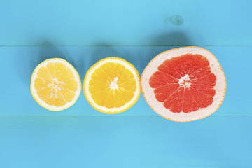 Citrus composition, orange, grapefruit and lemon on the blue wooden background.