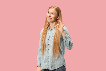 The happy business woman standing and smiling against pink background.