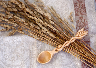  Handmade wooden spoon on linen tablecloth with dry grasses