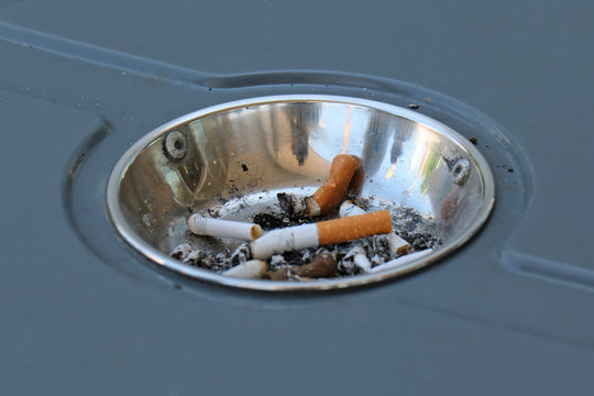 Cigarette butts inside ashtray in park