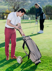 Obraz premium Male deciding on club while girl hitting ball
