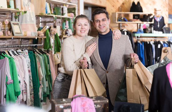 Young woman and man are standing satisfied with packadge after shopping