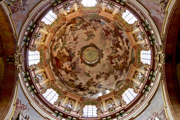 Obraz premium Cathedral dome with religious fresco - Christian paintings on a ceiling of St. Nicolas cathedral in Prague