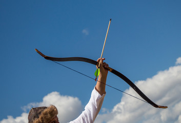 Archer in traditional clothes shooting an arrow