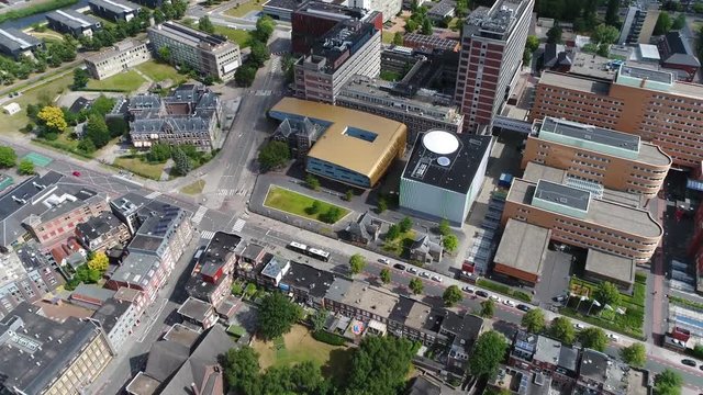 Aerial flight towards modern building located in Groningen city center showing the modern architecture of the nicely shaped building and bronze colored roof also showing classic buildings around it