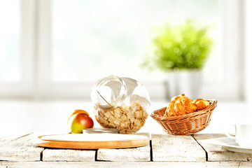 Continental breakfast and blurred background of white window with green plant. Free space for your decoration. 