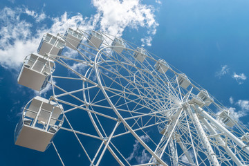 Empty white ferris wheel against the blue sky