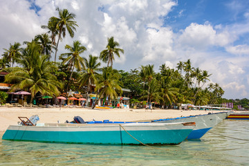 Obraz na płótnie Canvas Boats in the sea at a beautiful tropical beach. White sandy beach and crystal clear water sea. Philippines. Asia