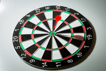 Obraz premium dart arrow hitting in the target center of dartboard. concept of the success