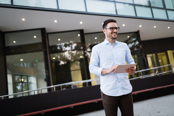 Portrait of businessman in glasses holding tablet