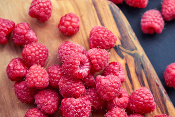 Fresh organic raspberries on black background. berries on a wooden spoon