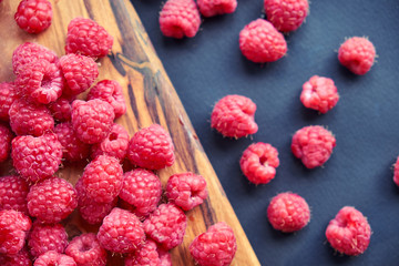 Fresh organic raspberries on black background. berries on a wooden spoon