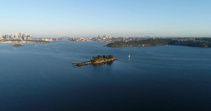 Sydney harbour Double Bay around Shark island in soft morning light hovering between shores looking at city CBD landmarks.

