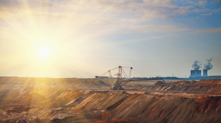 Industrial view of opencast mining quarry with machinery at work. Area has been mined for...