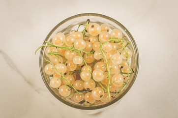 full glass of currant/full glass of currant on a white marble background, top view