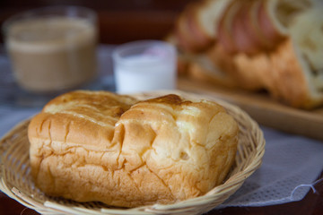 Bread, hot coffee and mike on wooden table.