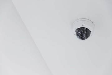 CCTV camera on white ceiling, security equipment