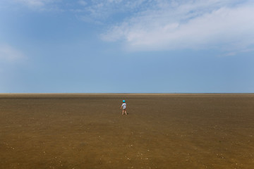 Kleiner Junge im trockenen Wattenmeer