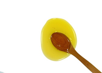 Honey in a wooden spoon isolated on white background.