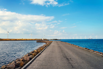 Fototapeta na wymiar Wind turbines in the sea, on a sunny summer day. Blue sky. Ecological energy. Denmark.