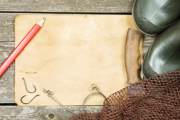 Fishing gear - fishing, pencil, hooks, boots, wooden background