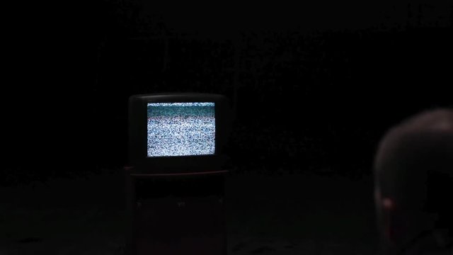 TV Television Interference Glitch. Stock. Man looks out of a broken TV. Concept of loneliness