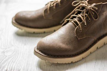 Close up vintage leather shoes man accessory. Men's casual outfits with accessories on rustic wood background,Men's accessories with brown leather shoes on wooden table