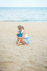 Naklejka premium happy family at the beach. motherand child daughter hug