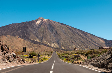 View of landscape of Teide National Park on Tenerife, Canarias islands, Spain. Yellow and black sand and distance view of mountains roads and volcano.