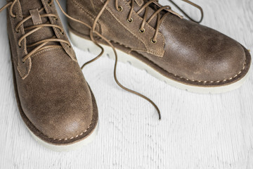 Close up vintage leather shoes man accessory. Men's casual outfits with accessories on rustic wood background,Men's accessories with brown leather shoes on wooden table