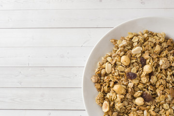 Dry Breakfast of oat flakes, granules and nuts. Muesli in a deep dish. Copy space.