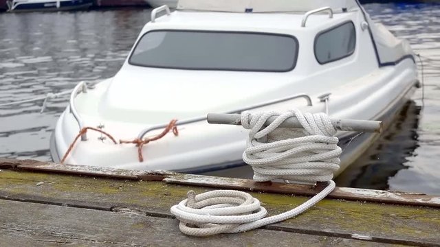 Shot of a white motorboat tied to a pier in a lovely summer day.